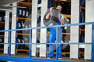 Auto mechanic carrying tire