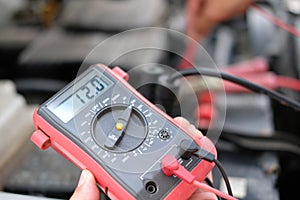 auto mechanic check car battery voltage by voltmeter multimeter