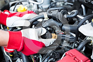 Auto mechanic checking car engine electrical connections