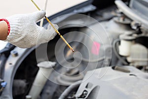 Auto mechanic checking the car engine oil level..Close up mechanic hand repairing car with open hood, mechanical checking motor