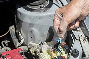 Auto mechanic checking a car fuse