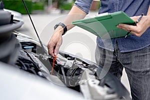 Auto mechanic checking the oil level in car engine, Check and maintenance the oil level in car