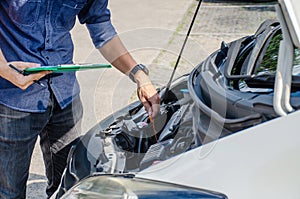 Auto mechanic checking the oil level in car engine, using a dipstick, Check and maintenance the oil level in car