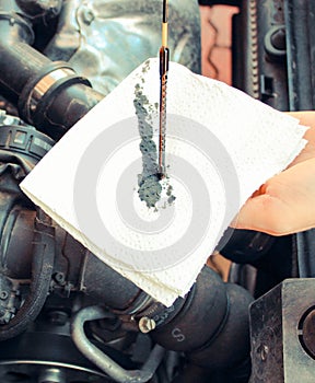Auto mechanic checking oil level in engine, technology
