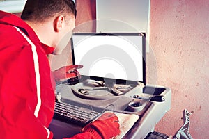 Auto mechanic checking the readout on a computer