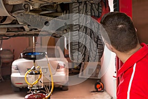 Auto mechanic checking the suspension on a car