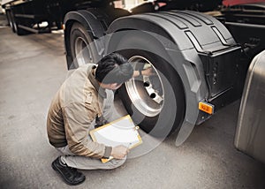 Auto Mechanic is Checking the Truck`s Safety Maintenance Checklist. Fixing. Inspection Safety of Semi Truck Wheels Tires