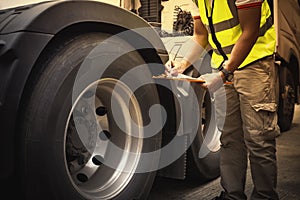 Auto Mechanic is Checking the Truck`s Safety Maintenance Checklist. Inspection Safety of Semi Truck Wheels Tires