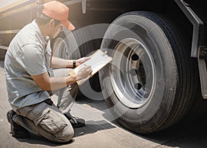 Auto Mechanic is Checking the Truck`s Safety Maintenance Checklist. Inspection Safety of Semi Truck Wheels Tires. Repair Shop.
