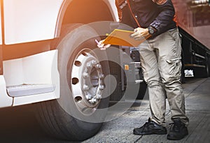 Auto Mechanic is Checking the Truck`s Safety Maintenance Checklist. Lorry Driver. Inspection Truck Safety of Semi Truck Wheels