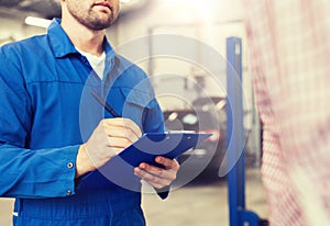 Auto mechanic with clipboard and man at car shop