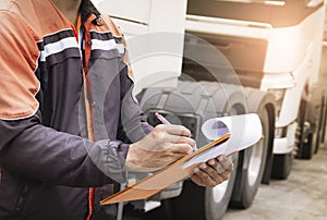 Auto Mechanic Driver holding Clipboard Checking Maintenance and Safety Program of Semi Truck.