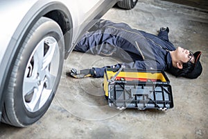 Auto mechanic feeling tired while working under car