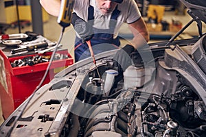Auto mechanic fixing car at repair service station