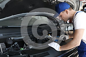 Auto mechanic fixing modern car in service center