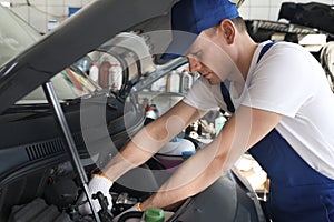 Auto mechanic fixing modern car in service center