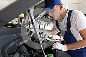 Auto mechanic fixing modern car in service center