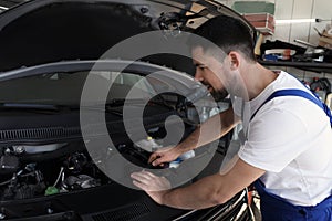 Auto mechanic fixing modern car in service center