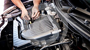 Auto mechanic hand fixing car engine in the garage