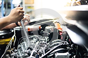 Auto mechanic hand fixing car engine in the garage