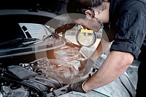 Auto mechanic handsome worker man checking engine, technician working in garage, car service technician repairing customer car