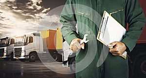 Auto Mechanic Holding A Wrench and Clipboard for Semi Truck Maintenance. Checking the Truck`s Safety. Repairman Service Shop.