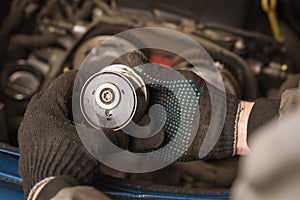 Auto mechanic inspects the timing belt tensioner roller of a passenger car
