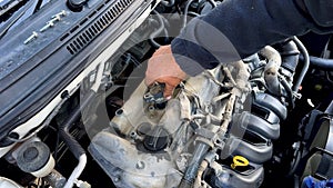 Auto mechanic Installing and checking the ignition coil of a car engine