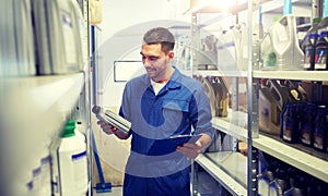 Auto mechanic with oil and clipboard at car shop