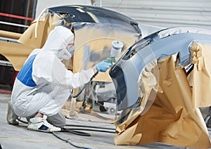 Auto mechanic painting car bumper