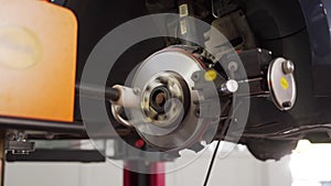 Auto mechanic refinishes brake disc with precision lathe. Vehicle servicing equipment in use for rotor resurfacing