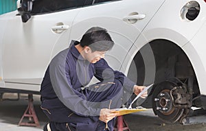 Auto mechanic repairman with a checklist, Technician checking modern car at garage