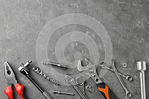 Auto mechanic`s tools on grey stone table. Space for text