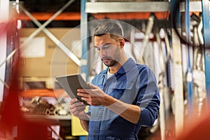 Auto mechanic or smith with tablet pc at workshop