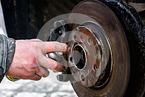 Auto mechanic spraying wheels with copper grease.