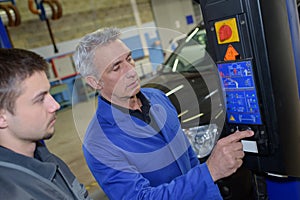 auto mechanic teacher and trainee performing tests at mechanic school