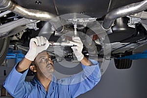 Auto mechanic under car photo