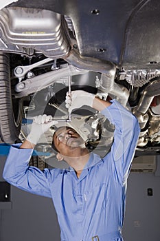 Auto mechanic under car photo