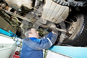 Auto mechanic at wheel alignment work with spanner