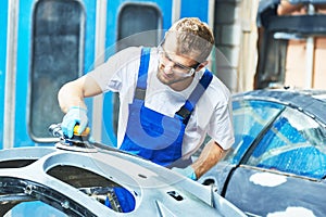 Auto mechanic worker polishing bumper car