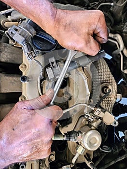 Auto mechanic working in auto repair service. Auto mechanic repairing a car.