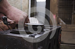 An auto mechanic is working on a car engine in a mechanics garage. Repair service. authentic close-up shot. VAZ 2106