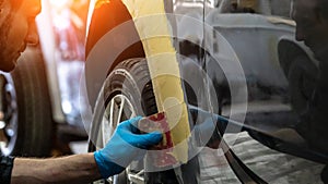 Auto mechanic working on car paint sanding in mechanics garage. workshop repair service. authentic close-up shot