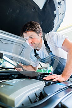 Auto mechanic working in car service workshop