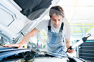 Auto mechanic working in car service workshop