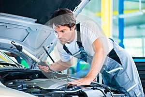 Auto mechanic working in car service workshop