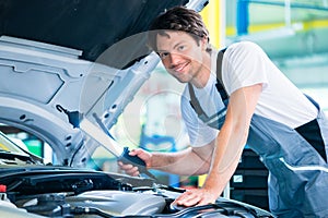 Auto mechanic working in car service workshop