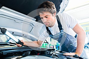 Auto mechanic working in car service workshop