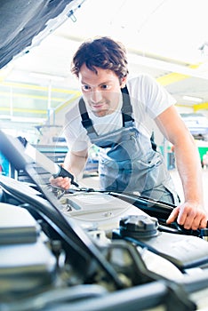 Auto mechanic working in car service workshop