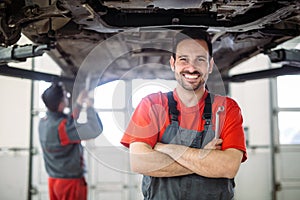 Auto mechanic working in garage. Repair service.